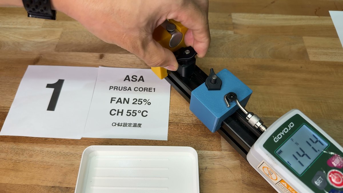 ASA・FAN25%・チャンバー設定55℃の条件札と、引張試験機の計器に141.4Nと表示された様子