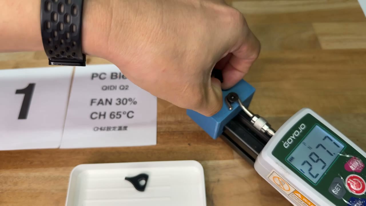PC Blendの試験片を引張試験機で引っ張り、計器に297.7Nと表示された様子